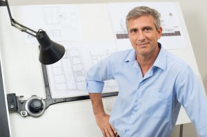 Portrait Of Male Architect With Blueprint At Office